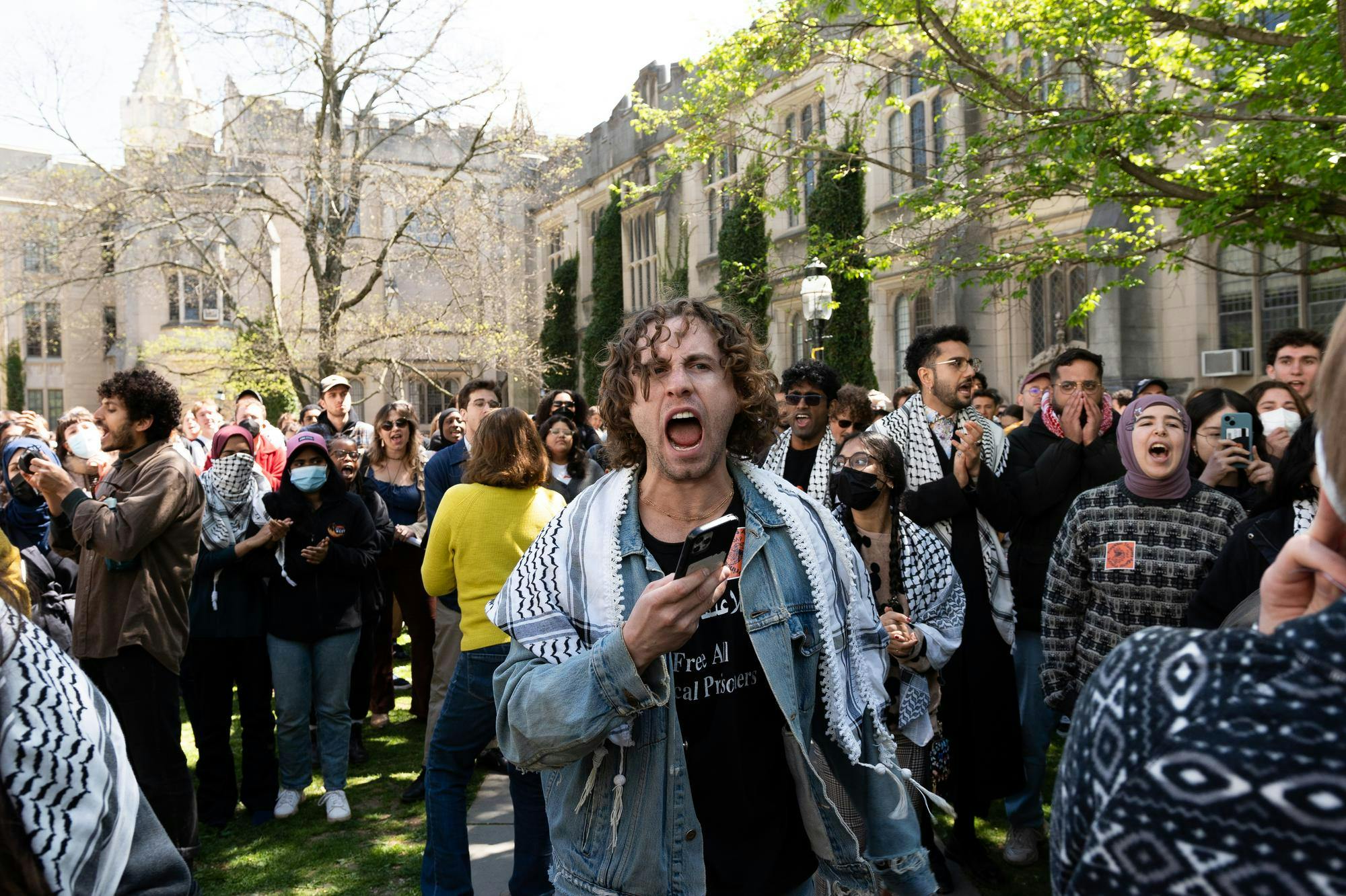 A man shouts from the center of a large crowd