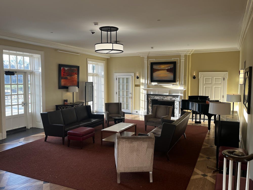 An open living room space with couches, chairs, a fireplace, and a piano.