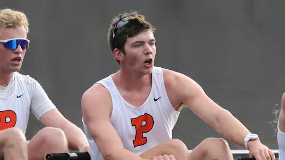 man in orange and white princeton uniform rows boat 