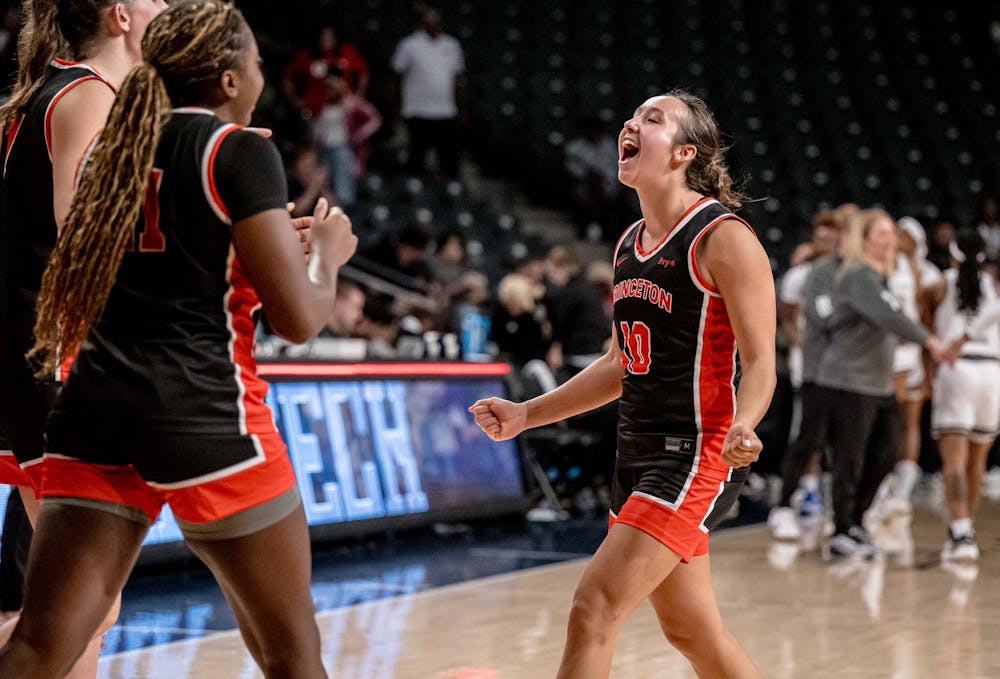 Players in black and orange basketball jerseys celebrate.