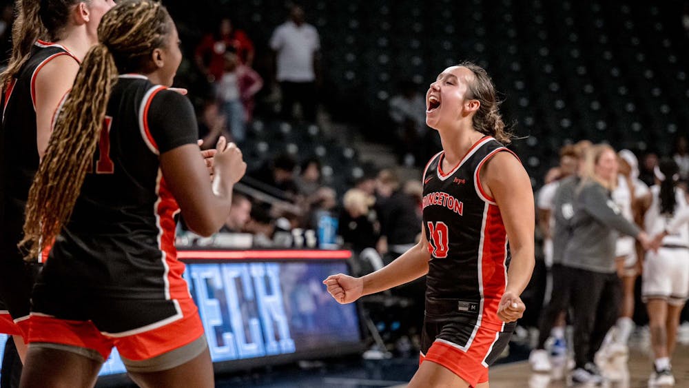 Players in black and orange basketball jerseys celebrate.
