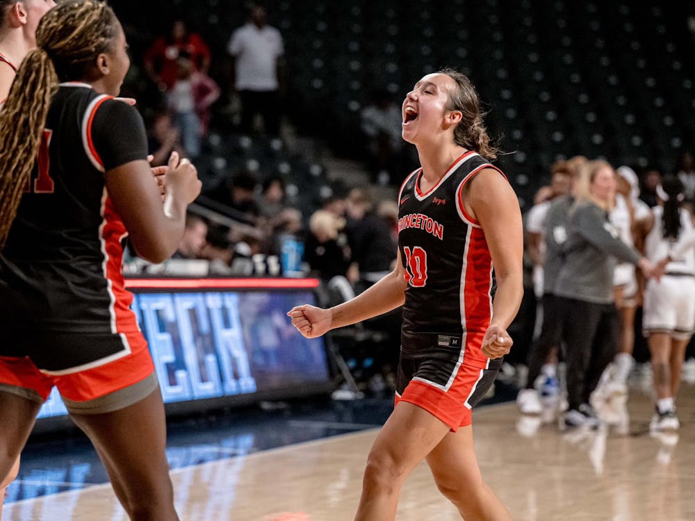 Players in black and orange basketball jerseys celebrate.