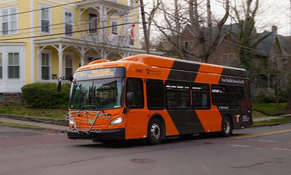 Un autóbus naranja de Tigertransit conducienco cerca de una área residencial. 