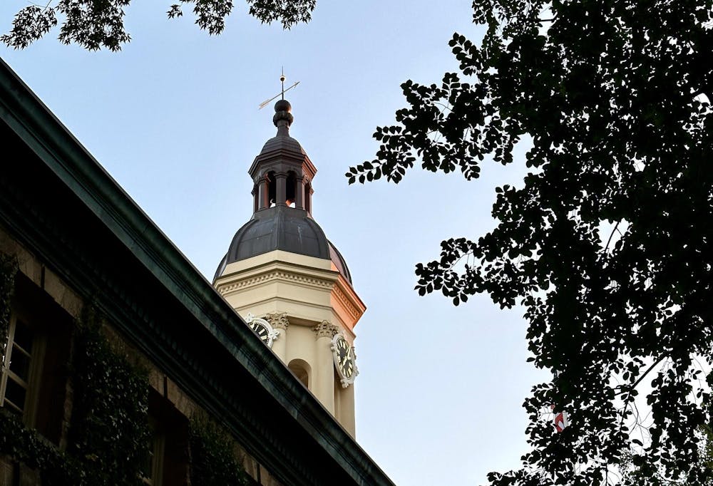 The tower of Nassau Hall is shown on the left and trees are shown on the right. 