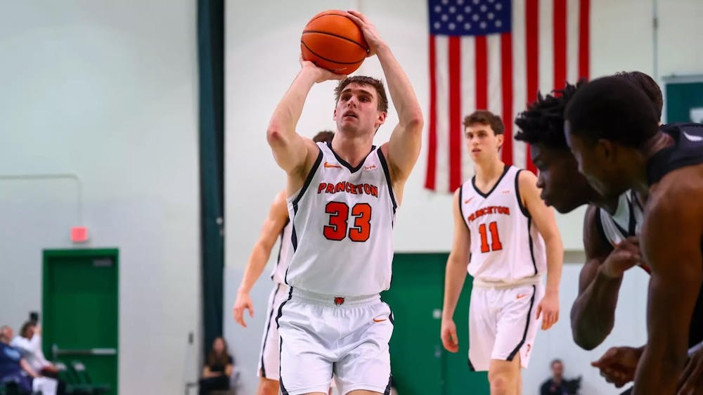 Princeton player in a white jersey shoots a free throw.