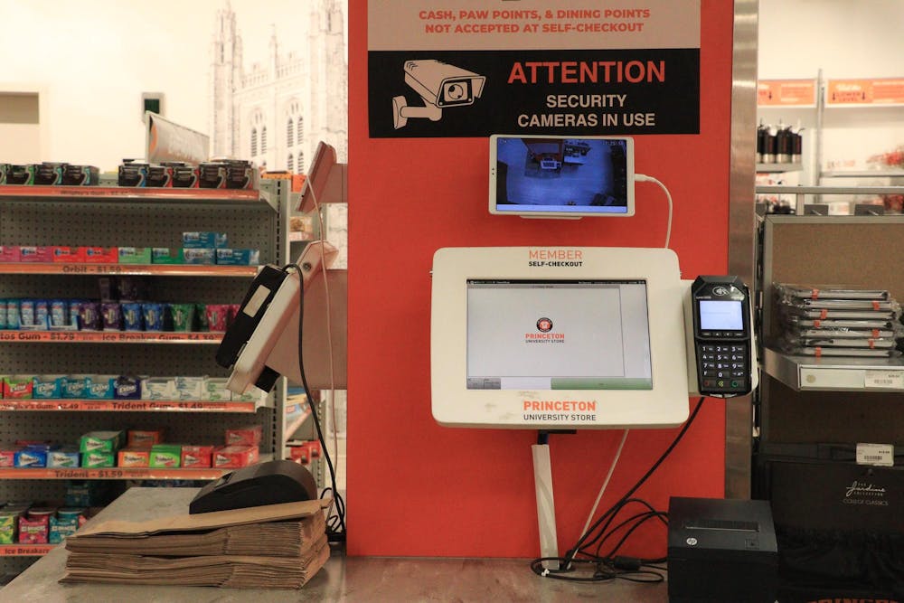 A self-checkout machine with a sign reading, “ATTENTION: SECURITY CAMERAS IN USE.”