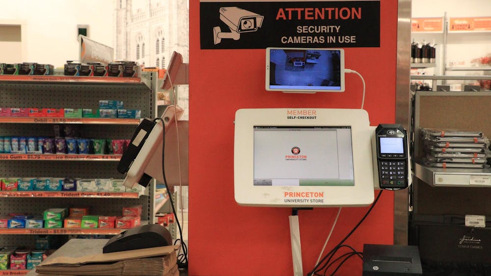 A self-checkout machine with a sign reading, “ATTENTION: SECURITY CAMERAS IN USE.”