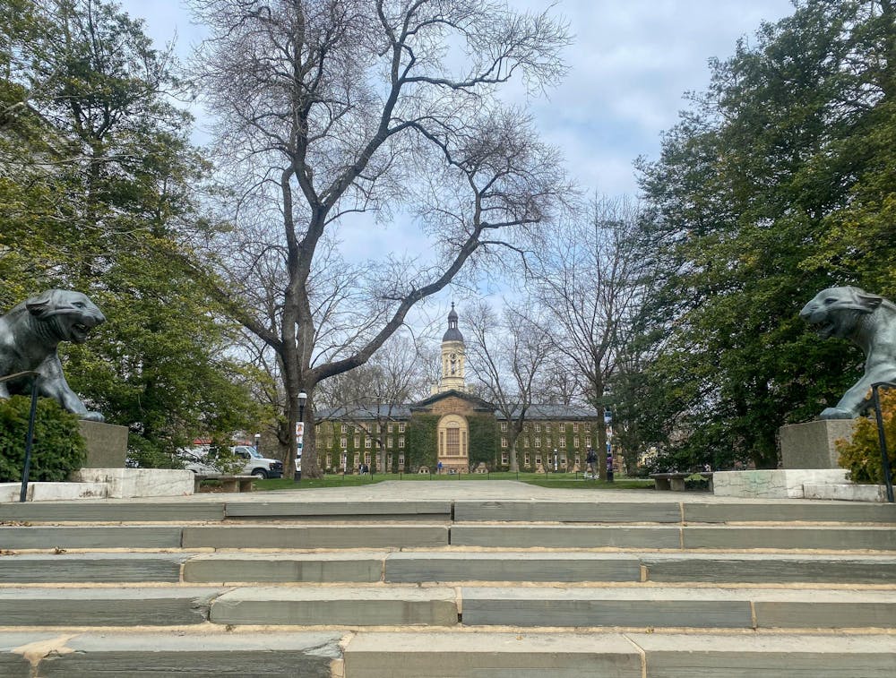 A set of stone steps flanked by two tigers. In the distance is a large building. 