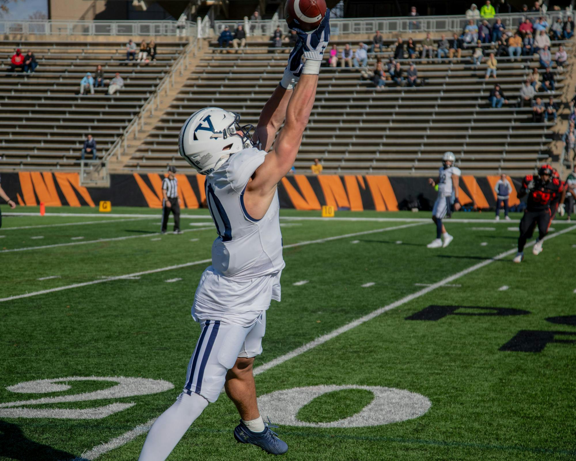 A Yale football player jumps to catch the football.
