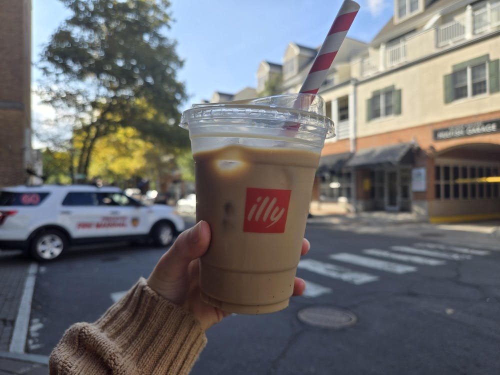 Plastic cup with iced coffee in it with a straw.