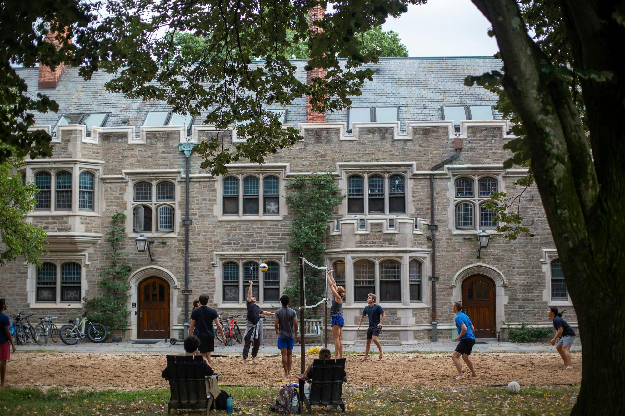 Eight students are playing volleyball in the Blair courtyard as two other students watch from the sidelines. 