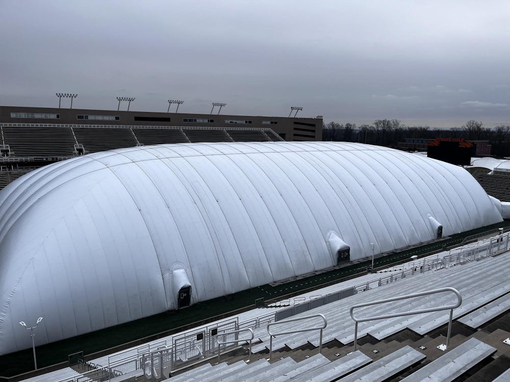 Gloomy skies over a football stadium. On the field sits a large white bubble.