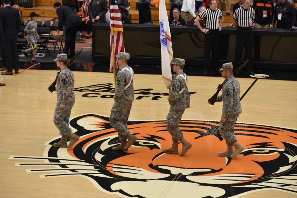 Rob, Visser, and two other cadets participating in color guard ceremony at home basketball game in Spring 2017.