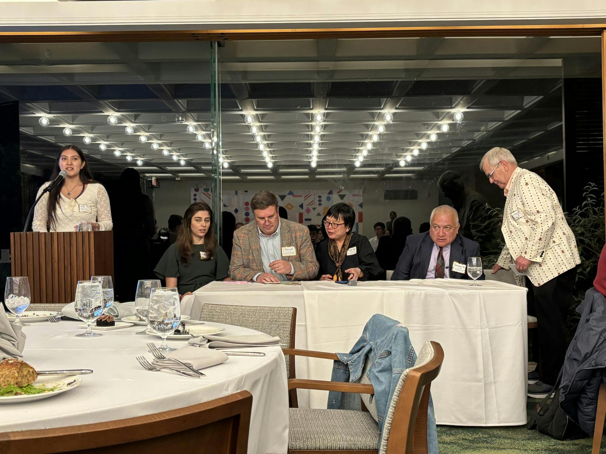 Several alumni sit at a table and answer questions. 