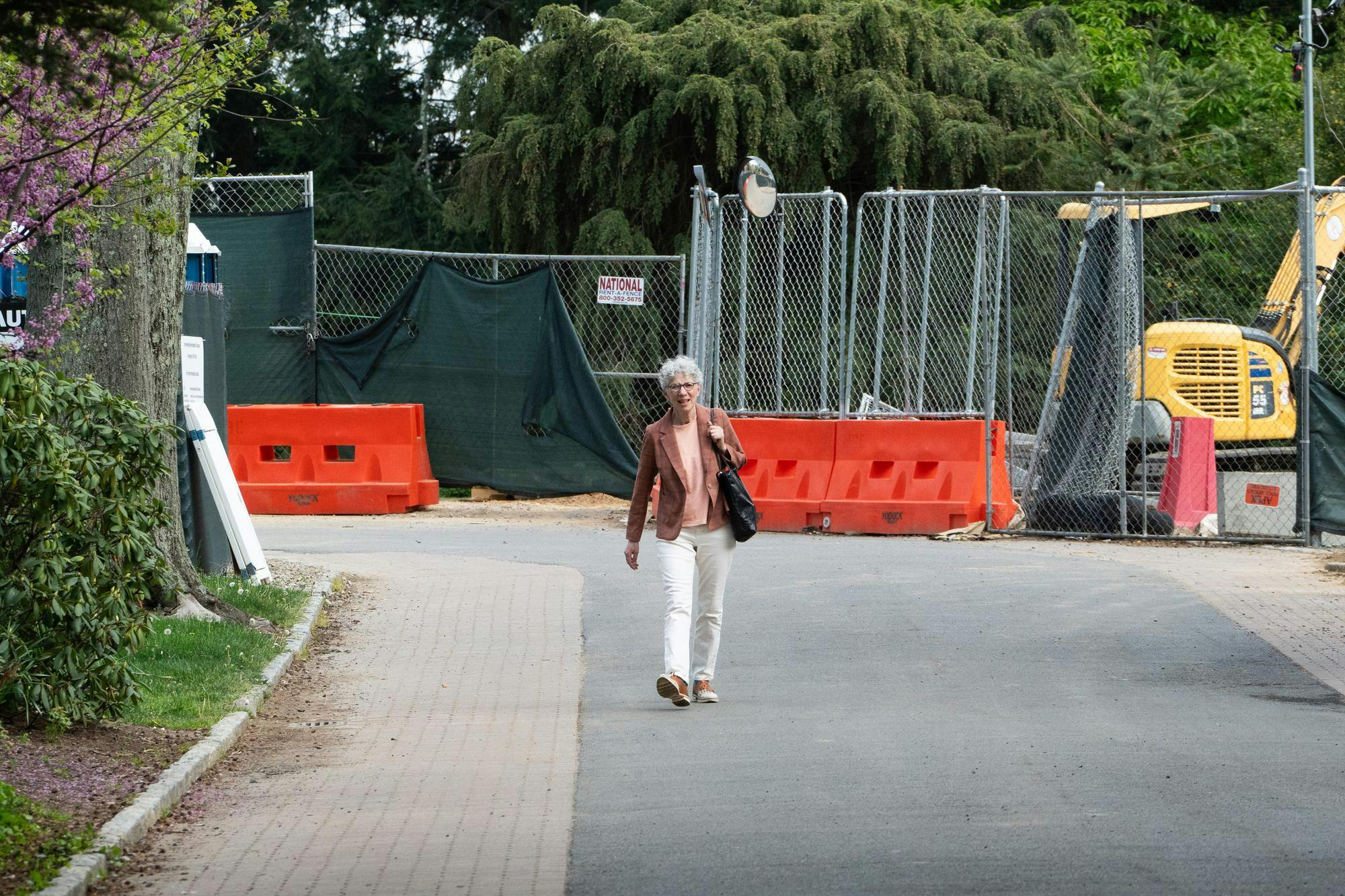 Dean Dolan walks earnestly on the road. Construction appears in the background.
