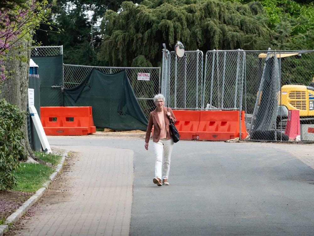 Dean Dolan walks earnestly on the road. Construction appears in the background.

