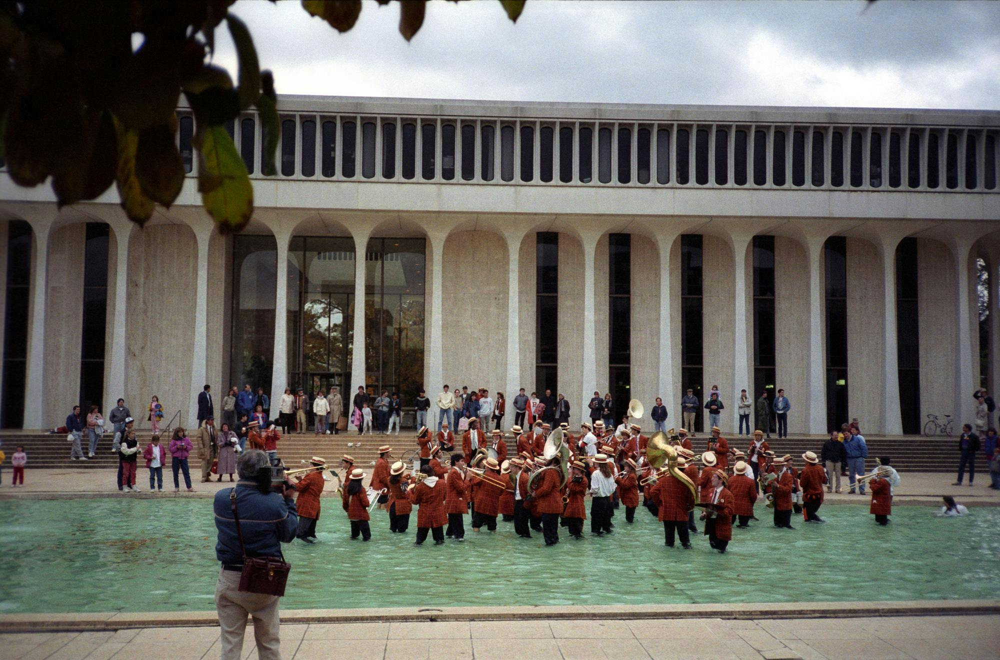 1988 Princeton University band playing in the SPIA fountain with spectators in the background and a videographer in the foreground