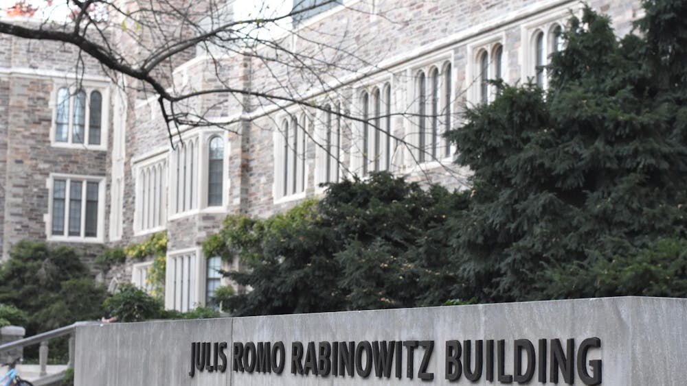 A sign reading Julis Romo Rabinowitz Building in the foreground of a gothic building.