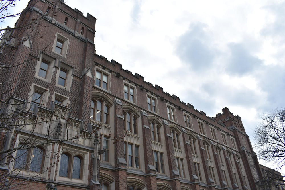 A large brick building with many windows spans the photo. The sky in the background is gray.