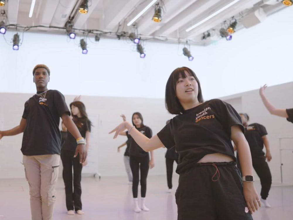 Group of dancers in a white space wearing black shirts.