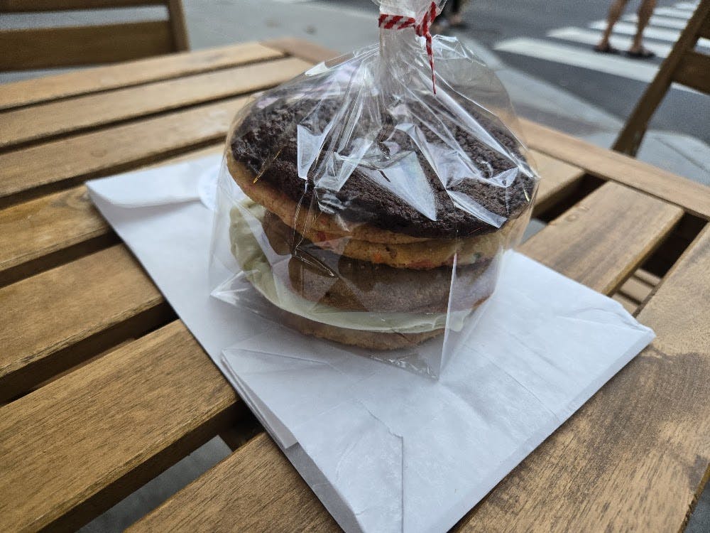 Clear plastic bag of cookies sitting on top of a white paper bag.