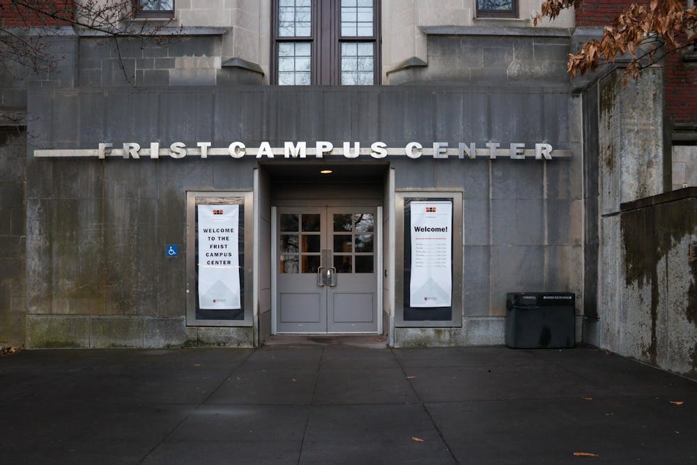 A gray building with a door. A sign above the door reads Frist Campus Center.