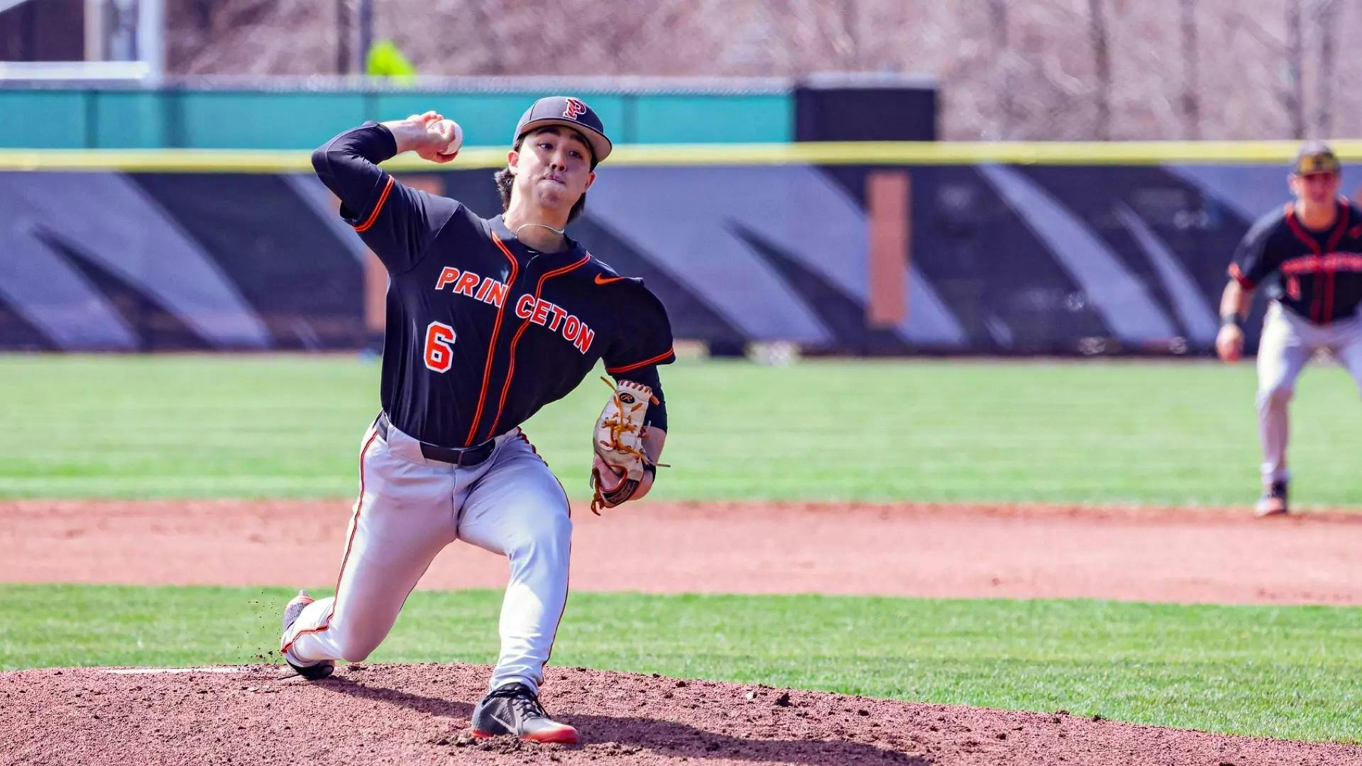 Princeton pitcher in black and orange uniform throws a pitch from the mound.