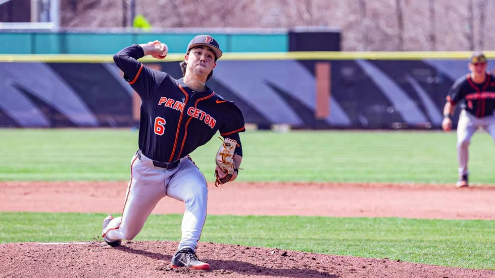 Princeton pitcher in black and orange uniform throws a pitch from the mound.