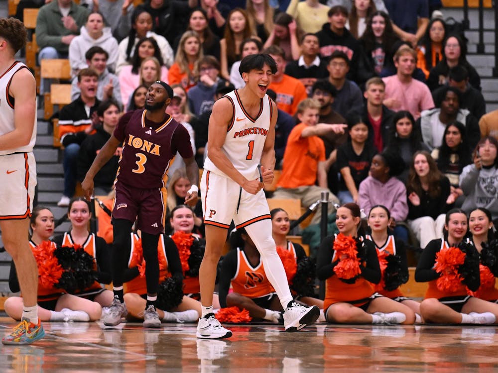On a basketball court, a player wearing a white jersey and white shorts looks happy after scoring a basket.