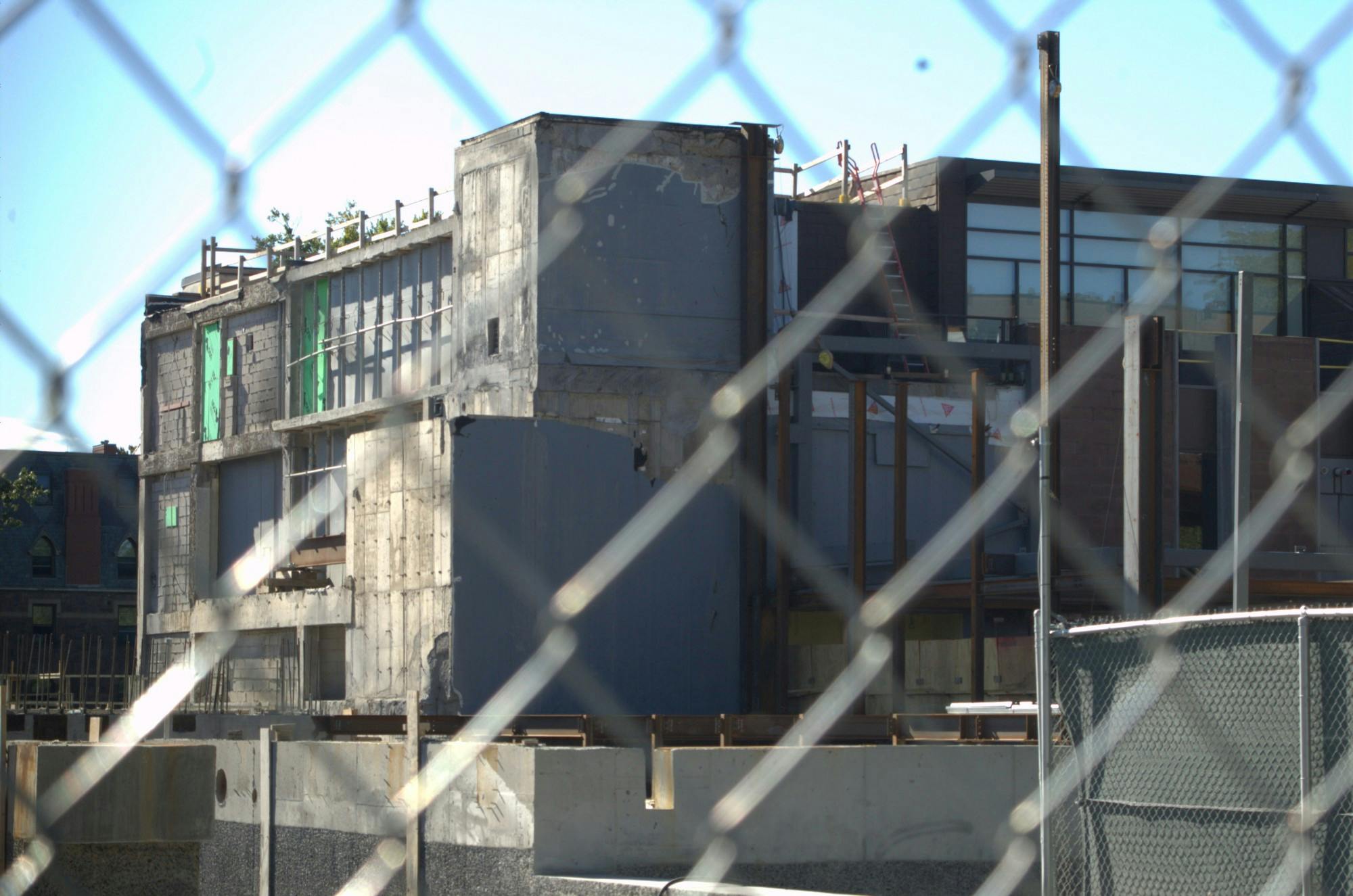 A fence overlays the Princeton Art Museum, which is currently under construction. The building is grey and unfinished.