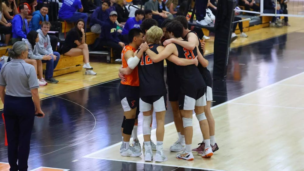 A group of men’s volleyball players huddling up.
