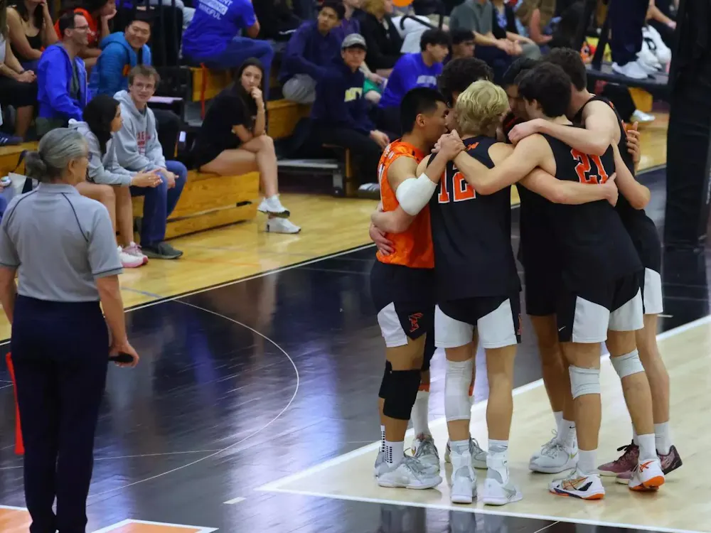 A group of men’s volleyball players huddling up.