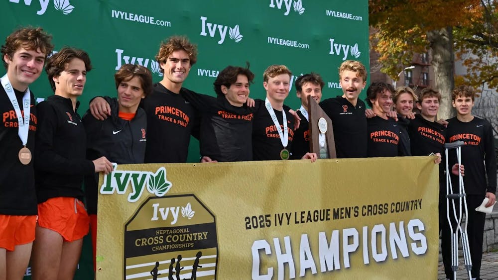 Twelve runners in black shirts smile with gold medals around their necks.