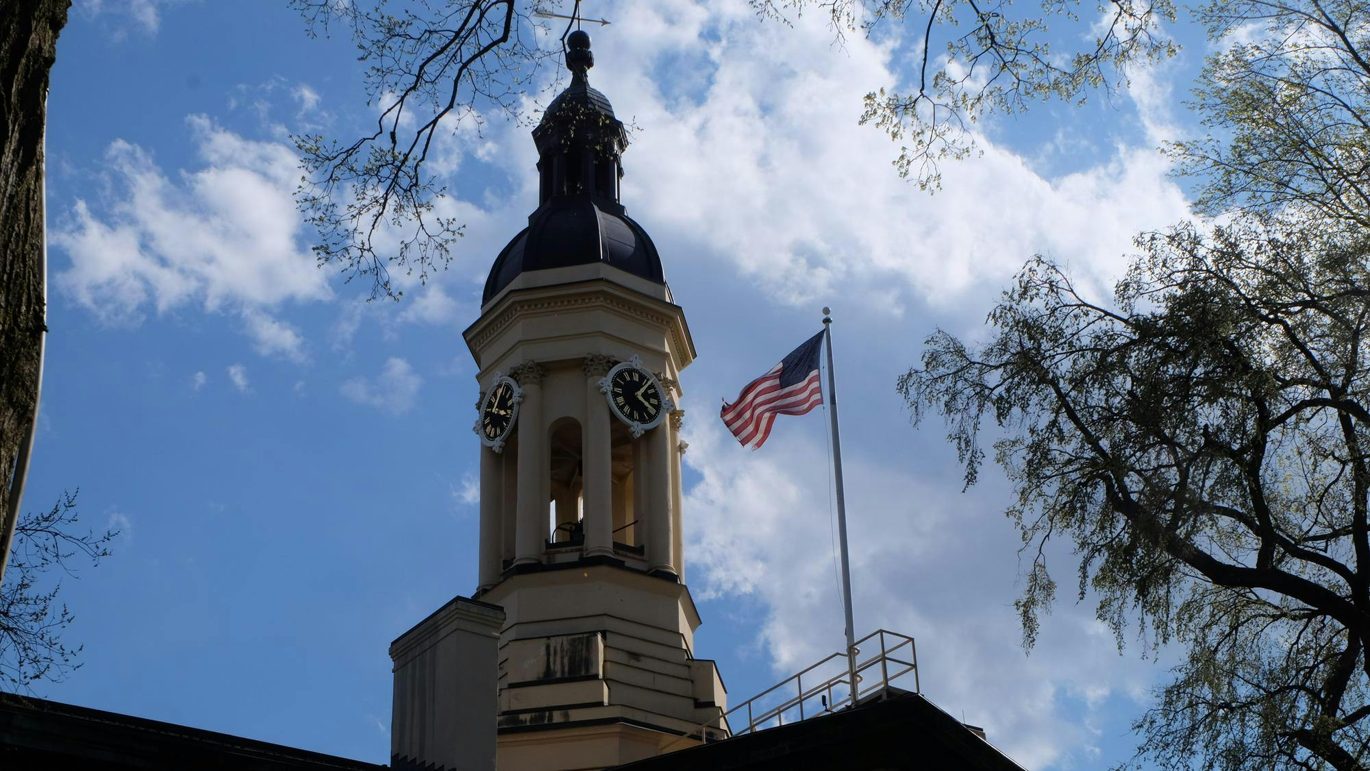 The top of Nassau Hall and an American Flag.