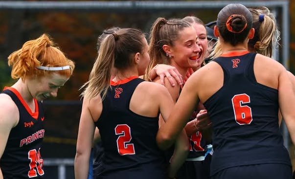 Princeton field hockey in a huddle.