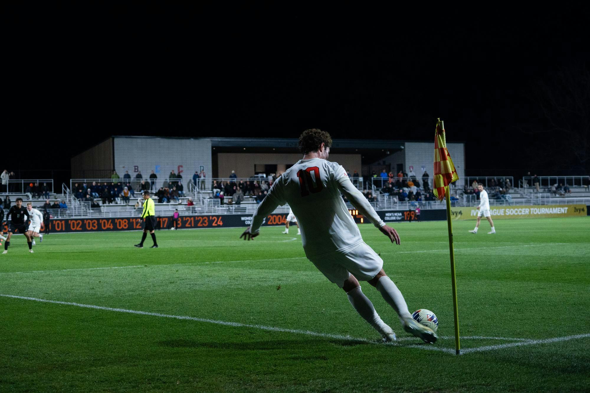 Soccer player in white sends in a corner 