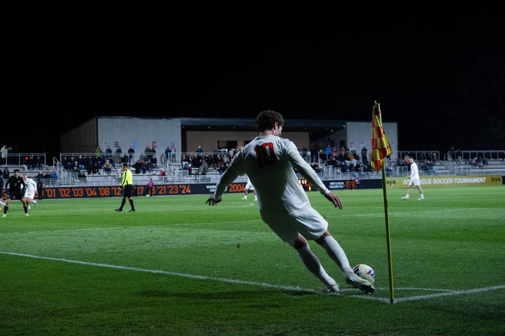 Soccer player in white sends in a corner 