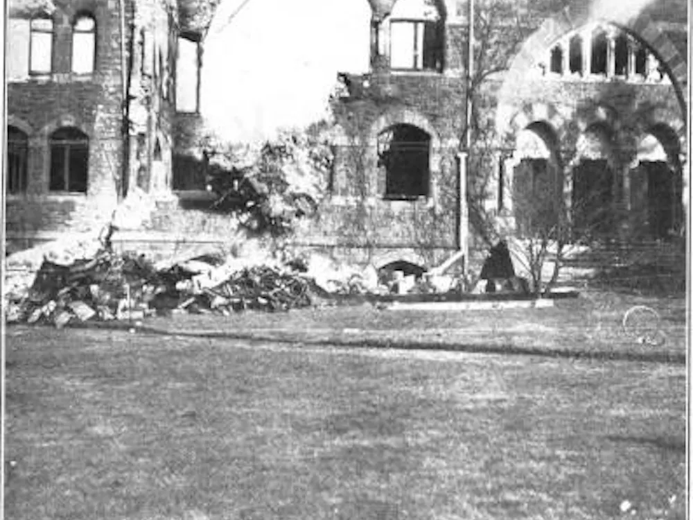 A black and white photograph of the High Victorian Gothic-style John C. Green School of Science with rubble at the base.
