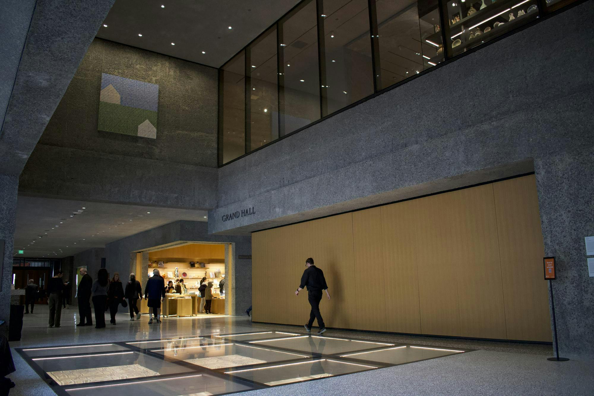 A large room with a glass floor and cement and yellow paneled wall.