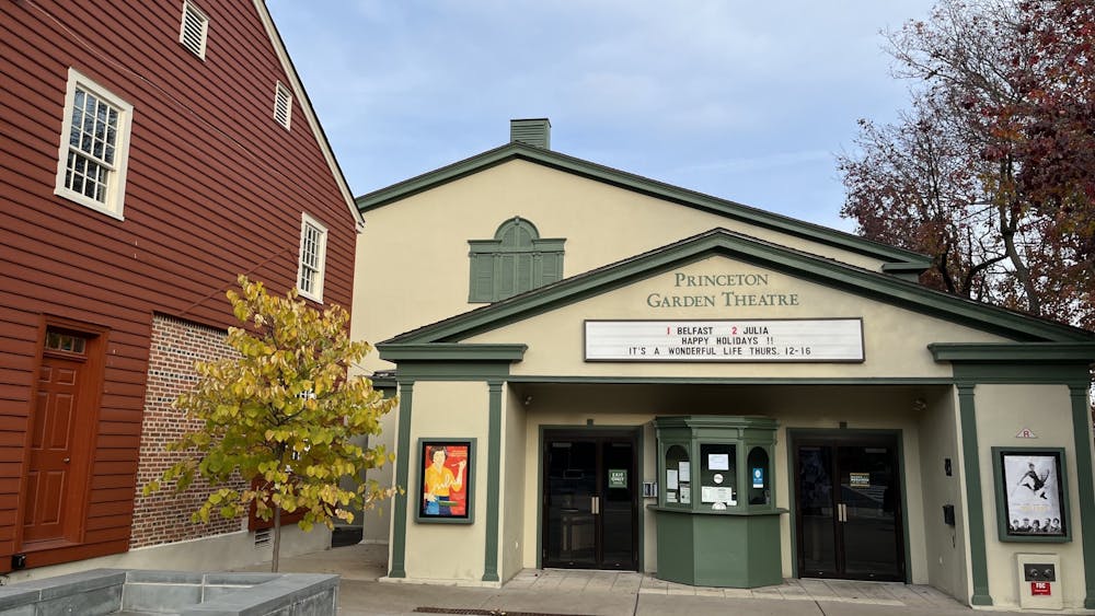 Cream colored building with green trimming, next to red-panneled building.