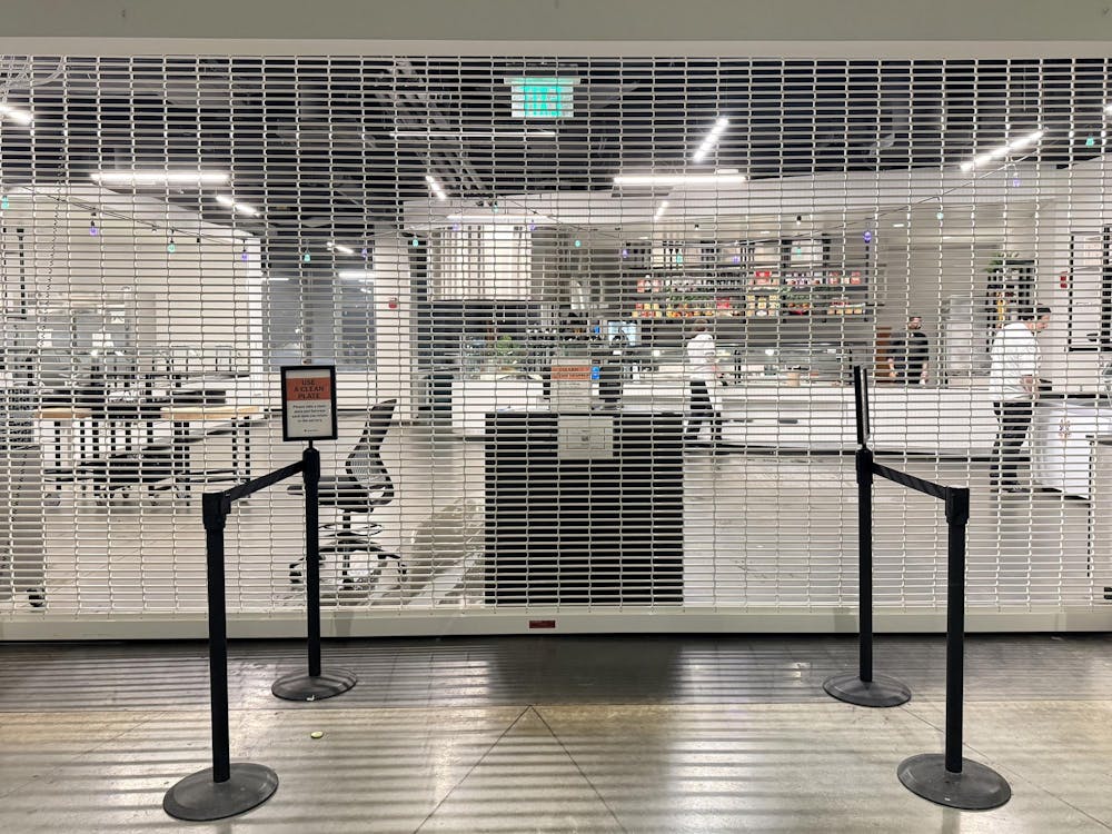 A gate has been pulled down in front of a dining hall entrance.