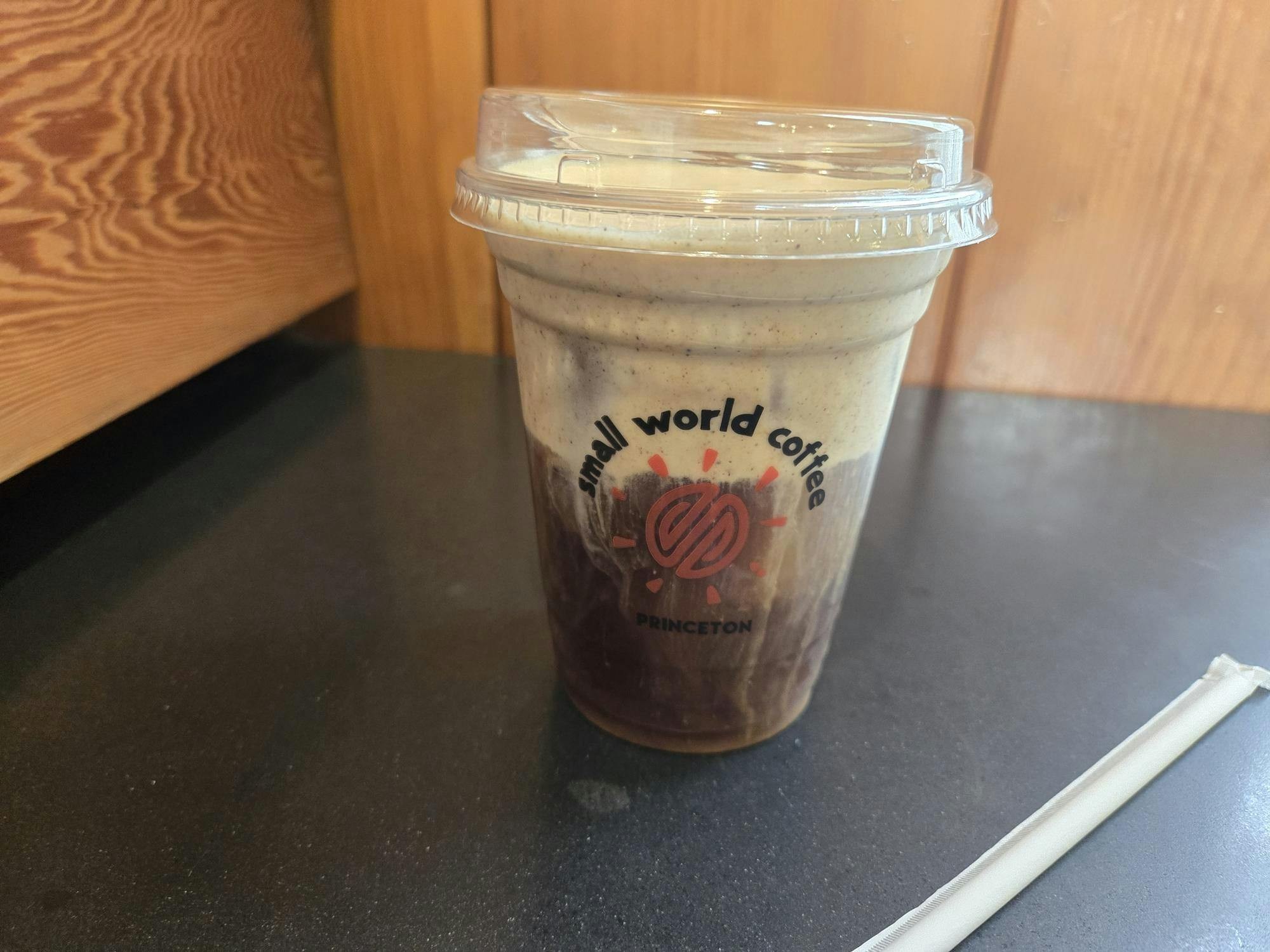 A cup of cold brew coffee with foam on top.