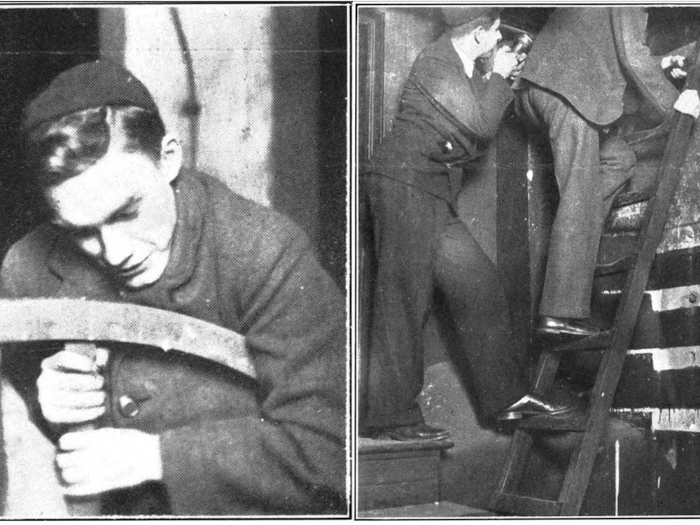 First years in 1929 wear black skullcaps as they attempt to steal the clapper from Nassau Hall. One holds a large wheel while another is pictured climbing a ladder.