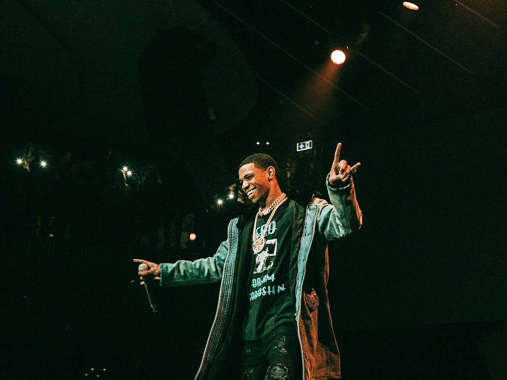 A man on a stage with a mic on his right hand performing