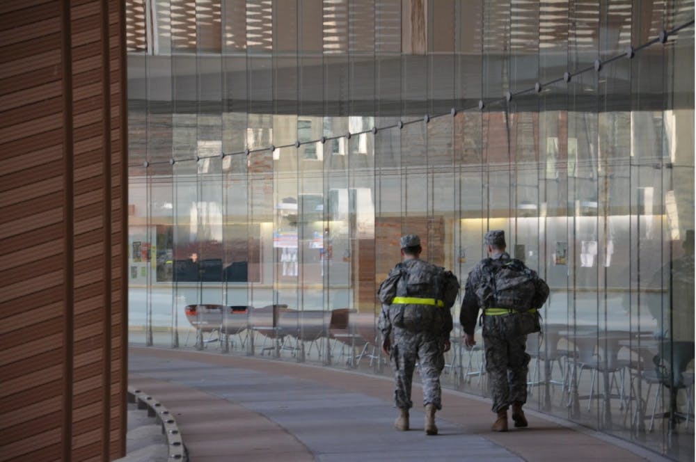 Two cadets walking past Icahn Hall.