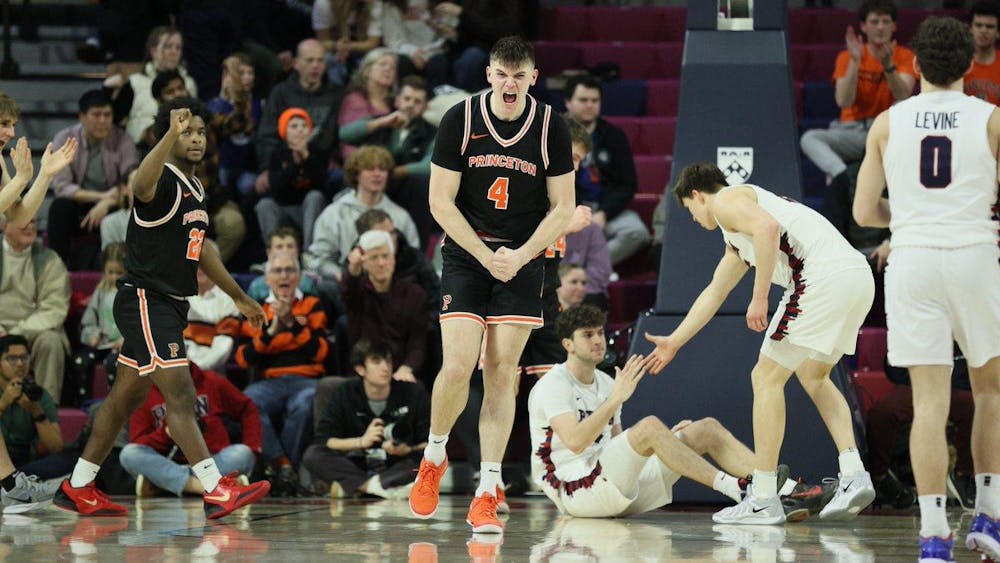 A man wearing a black jersey and black shorts excited after scoring a basket during a basketball game. 