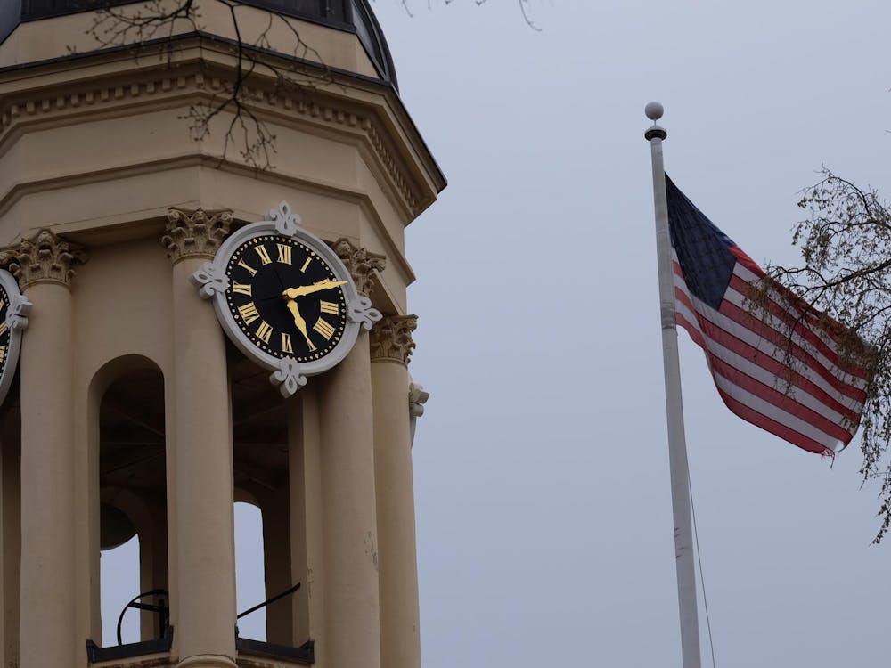 A clock tower on the left and an American flag on the right