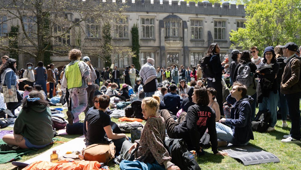 Students walking and sitting on McCosh Courtyard in a public demonstration for solidarity with pro-Palestinian sit-ins.
