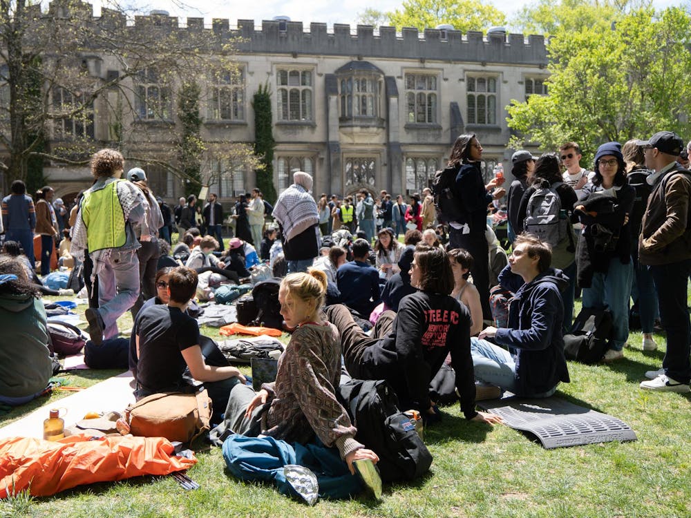 Students walking and sitting on McCosh Courtyard in a public demonstration for solidarity with pro-Palestinian sit-ins.