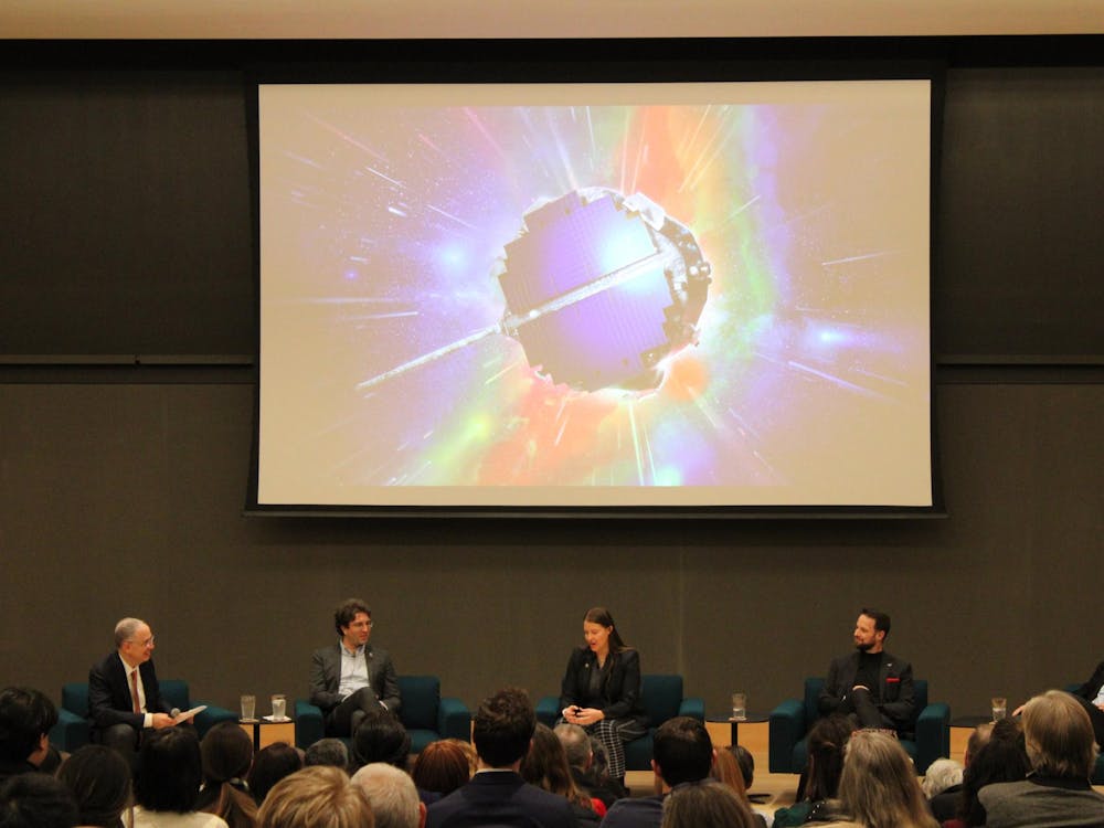 Five people in suits sit in front of a projector showing a space probe.